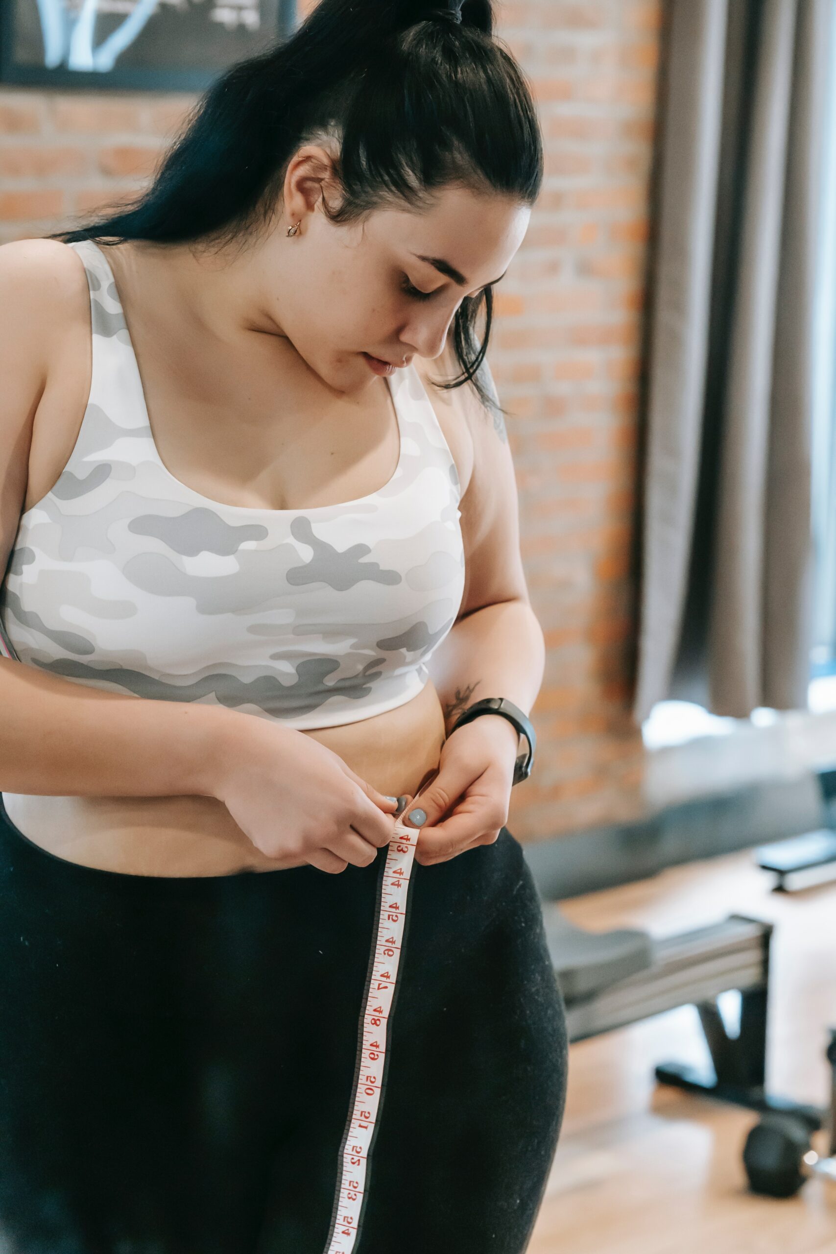 Woman measuring her waist post-workout
